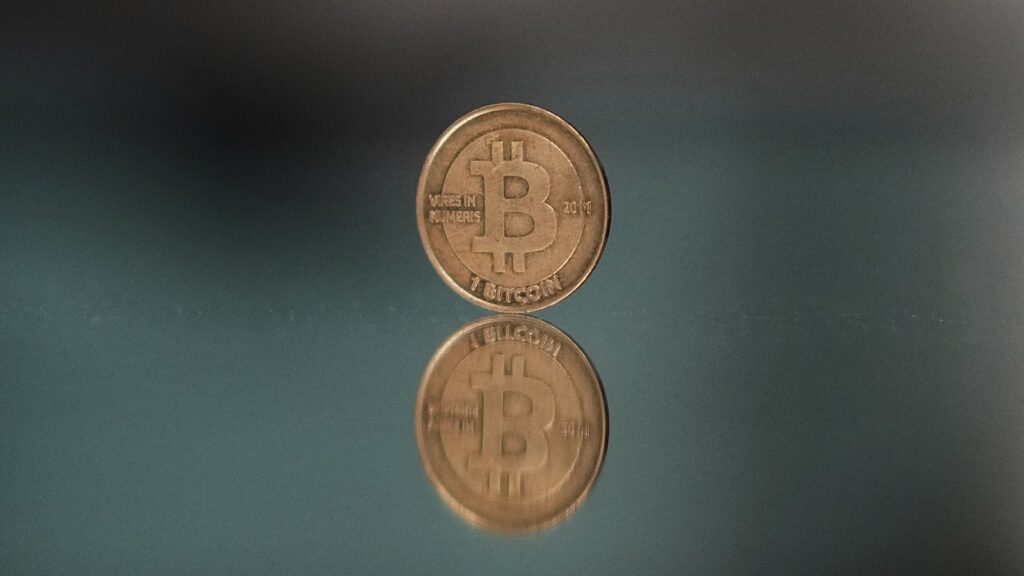 A one bitcoin token reflects as it is placed on a mirror in Prague