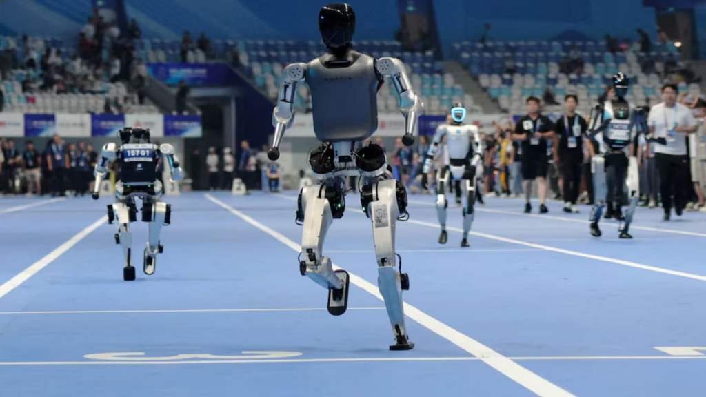 Humanoid robots take part in a test 100m run ahead of the opening ceremony of the inaugural World Humanoid Robot Games, at National Speed Skating Oval, in Beijing, China, August 14, 2025. (Image Source: Reuters)