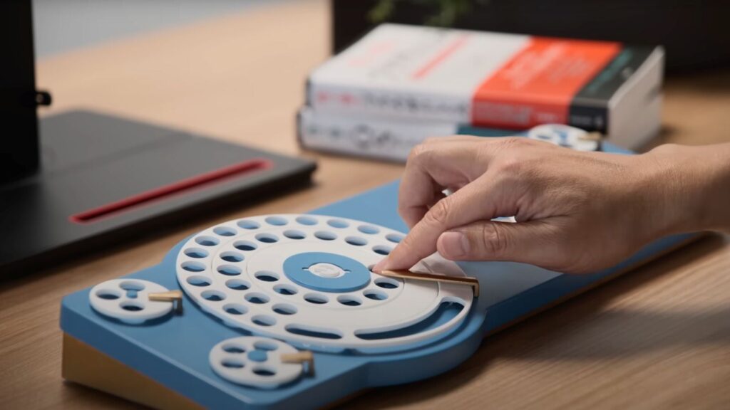 Rotary phones once used pulse dialling—creating electrical pulses that represented numbers—but in Google’s version, sensors detect the dial’s return motion and convert it into USB signals readable by computers. (Image: Youtube/Google Japan)