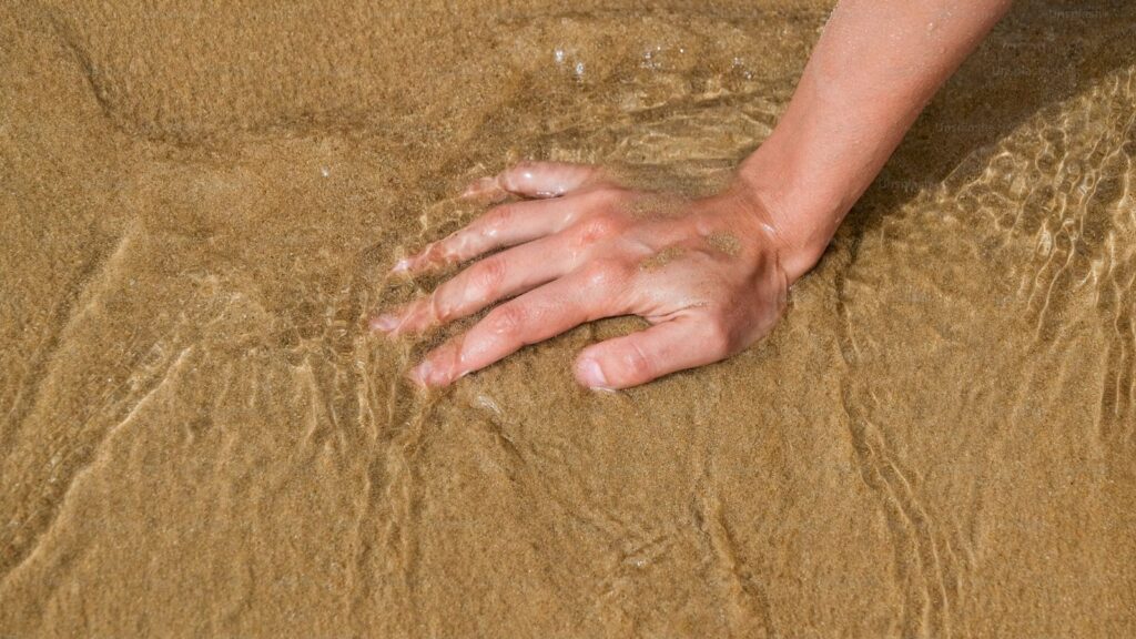 These findings challenge traditional assumptions about the limits of touch and suggest that the sensory capacity of human hands approaches the theoretical threshold for detecting mechanical reflections in granular media. (Image: Unsplash)